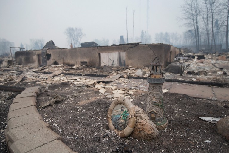 FORT MCMURRAY, AB - MAY 07: Home foundations and skeletons of possesions are all that remain in parts of a residential neighborhood destroyed by a wildfire on May 7, 2016 in Fort McMurray, Canada. Wildfires, which are still burning out of control, have forced the evacuation of more than 80,000 residents from the town. Scott Olson/Getty Images/AFP