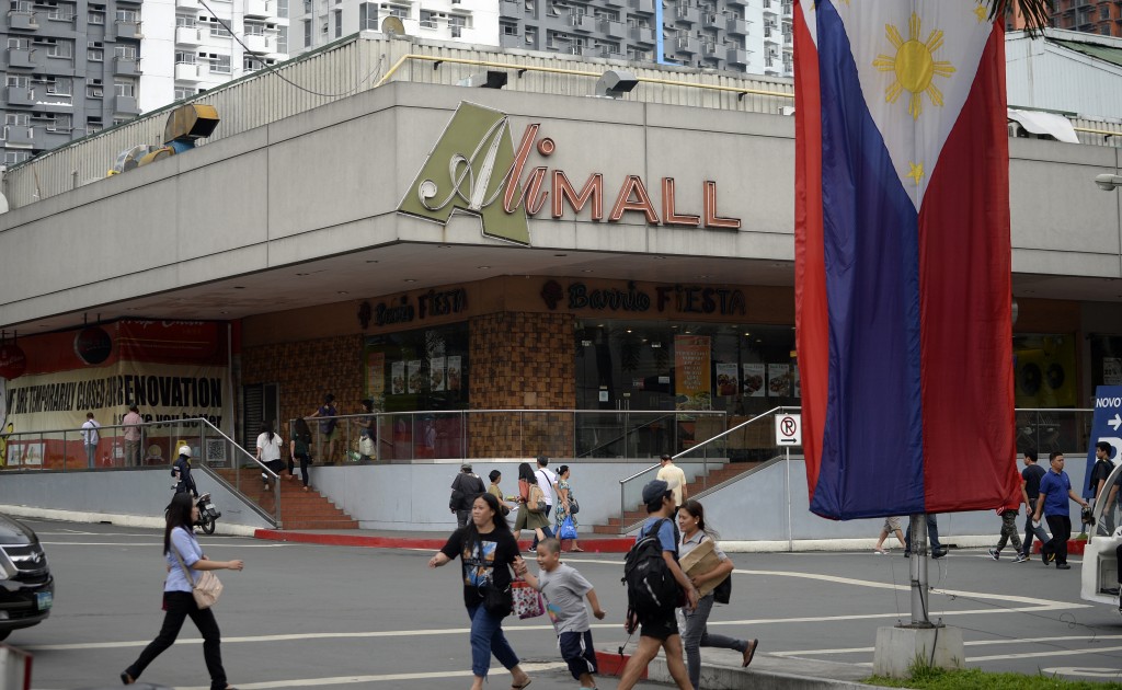 Shoppers walk in front of "Ali-Mall", named after Muhammad Ali as he won a boxing match called "Thrilla in Manila" against Joe Frazier on Araneta Coliseum on October 1, 1975, in this picture taken on on Manila June 6, 2016. A bustling shopping mall forms an unlikely monument to the "Thrilla in Manila", but Muhammad Ali's most brutal fight made its biggest impression on the minds of those who witnessed it and still speak of it with awe. / AFP PHOTO / NOEL CELIS