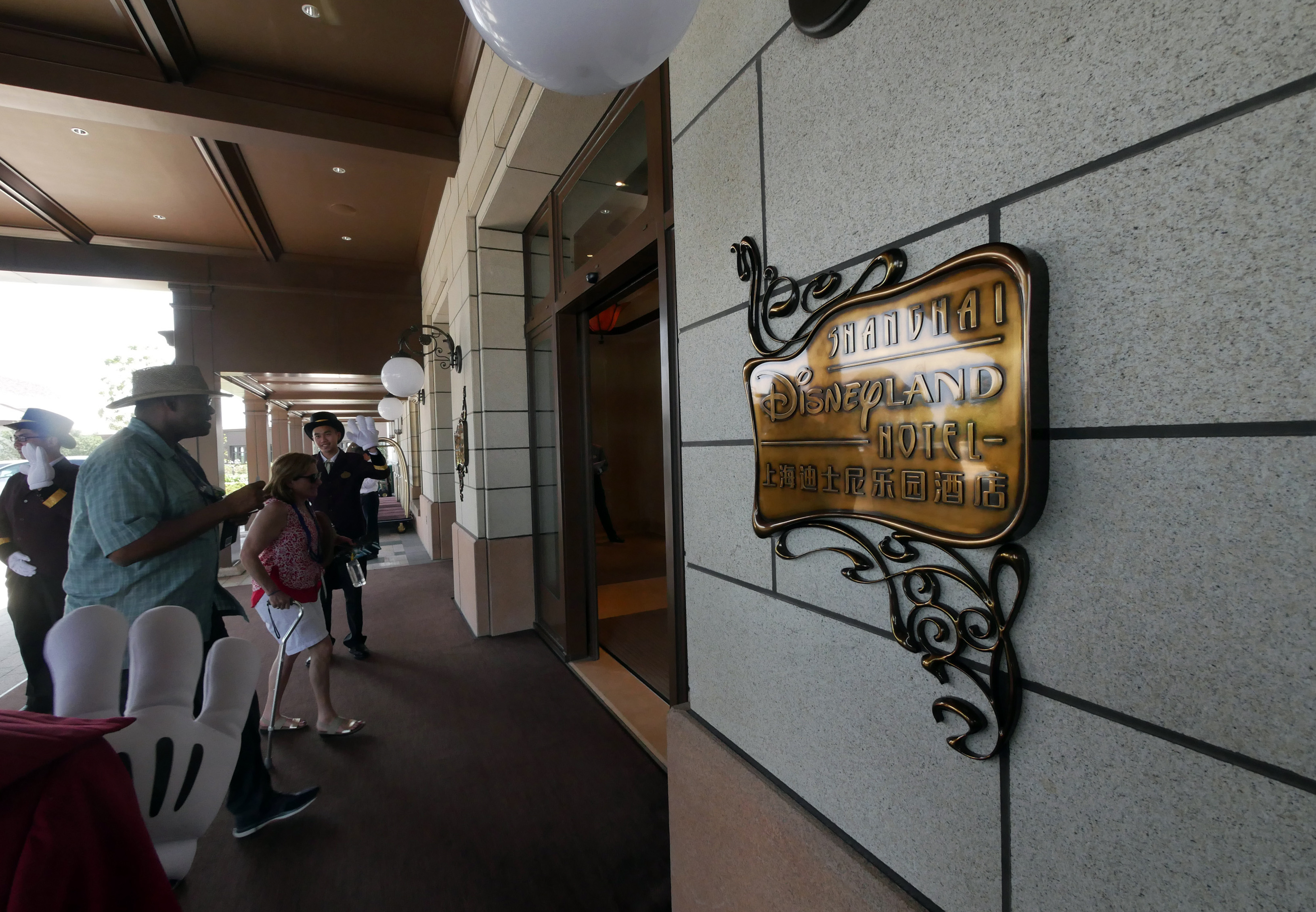 Guests walk into the Shanghai Disneyland Hotel at the Shanghai Disney Resort in Shanghai on June 14, 2016.  The Magic Kingdom comes to the Middle Kingdom this week when Disney opens its first theme park in mainland China, betting the growing middle class will spend big on leisure despite a slowing economy. / AFP PHOTO / STR