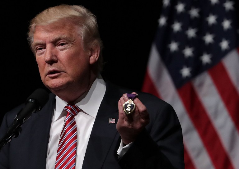 ASHBURN, VA - AUGUST 02: Republican presidential nominee Donald Trump holds a Purple Heart, given to him by veteran Louis Dorfman, during a campaign event at Briar Woods High School August 2, 2016 in Ashburn, Virginia. Trump continued to campaign for his run for president of the United States.   Alex Wong/Getty Images/AFP