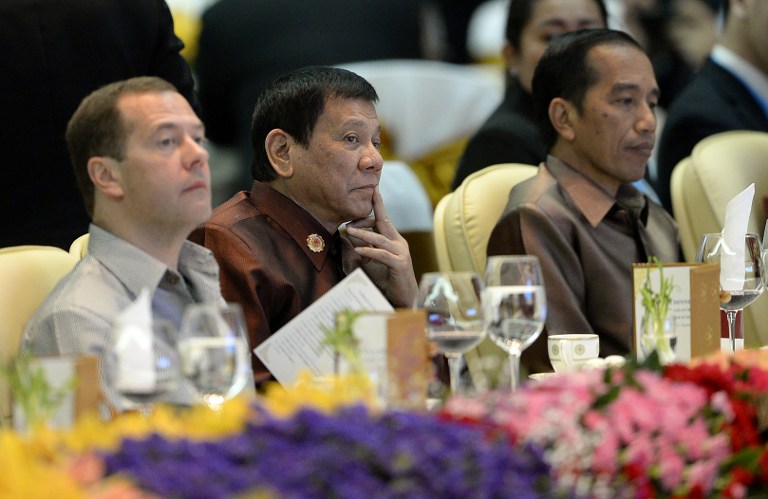 Philippine President Rodrigo Duterte (C) sits beside Russian Prime Minister Dmitry Medvedev (L) and Indonesia's President Joko Widodo at the gala dinner during the second day of the Association of Southeast Asian Nations (ASEAN) Summit in Vientiane on September 7, 2016. / AFP PHOTO / NOEL CELIS