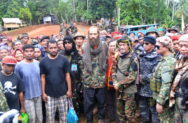 Moro National Liberation Front (MNLF) chairman Nur Misuari (4th R) poses for photos with freed Norwegian national Kjartan Sekkingstad (C), and three Indonesians (front L-R) during their turn-over ceremony in Indanan town, Sulu province, in southern island of Mindanao on September 18, 2016. / AFP PHOTO / NICKEE BUTLANGAN