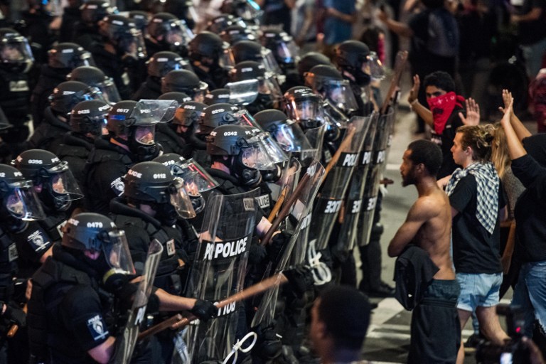 CHARLOTTE, NC - SEPTEMBER 21: Police officers in riot gear approach demonstrators on September 21, 2016 in downtown Charlotte, NC. The North Carolina governor has declared a state of emergency in the city of Charlotte after clashes during protests in the city in response to the fatal shooting by police officers of 43-year-old Keith Lamont Scott at an apartment complex near UNC Charlotte.   Sean Rayford/Getty Images/AFP