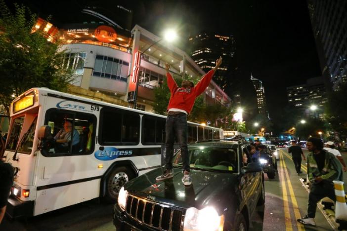 A man stands on a car in uptown Charlotte, NC to protest the police shooting of Keith Scott, in Charlotte, North Carolina, U.S. September 21, 2016. REUTERS/Jason Miczek