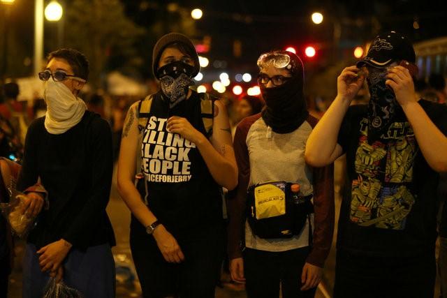 Demonstrators make a line across the road after curfew while protesting the police shooting of Keith Scott in Charlotte, North Carolina, U.S., September 25, 2016.     REUTERS/Mike Blake