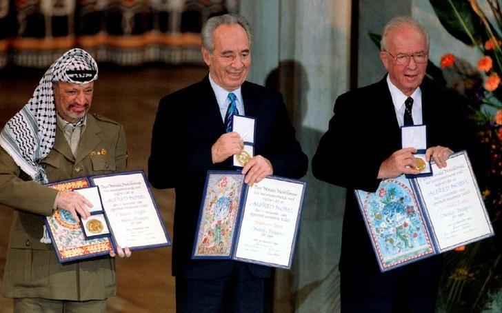 PLO Chairman Yasser Arafat, Israeli Foreign Minister Shimon Peres and Israeli Prime Minister Yitzhak Rabin (from L to R) show their shared Nobel Peace Prize awards to the audience in the Oslo City Hall in Oslo in this December 10, 1994 file photo. REUTERS/Jerry Lampen/Files