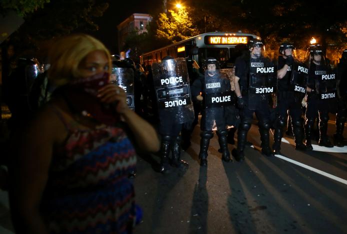 A demonstrator is greeted by police in riot gear while continuing to protest after curfew in Charlotte, North Carolina, U.S., September 25, 2016.     REUTERS/Mike Blake