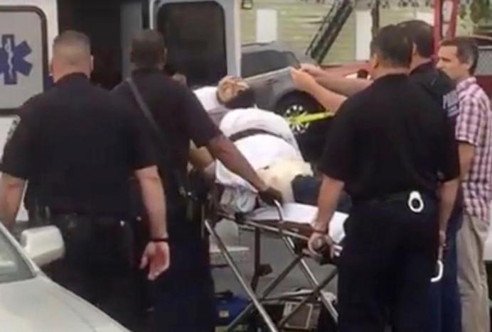 A policeman takes a photo of a man they identified as Ahmad Khan Rahami, who is wanted for questioning in connection with an explosion in New York City, as he is placed into an ambulance in Linden, New Jersey, in this still image taken from video September 19, 2016. REUTERS/Anthony Genaro