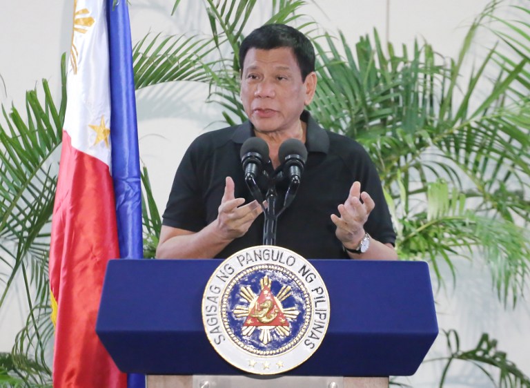 Philippines President Rodrigo Duterte delivers a speech at the Davao international airport terminal building early on September 30, 2016, shortly after arriving from an official visit to Vietnam. Duterte on September 30 drew a parallel with his deadly crime war and Hitler's massacre of Jews, as he said he was "happy to slaughter" millions of drug addicts. / AFP PHOTO / MANMAN DEJETO