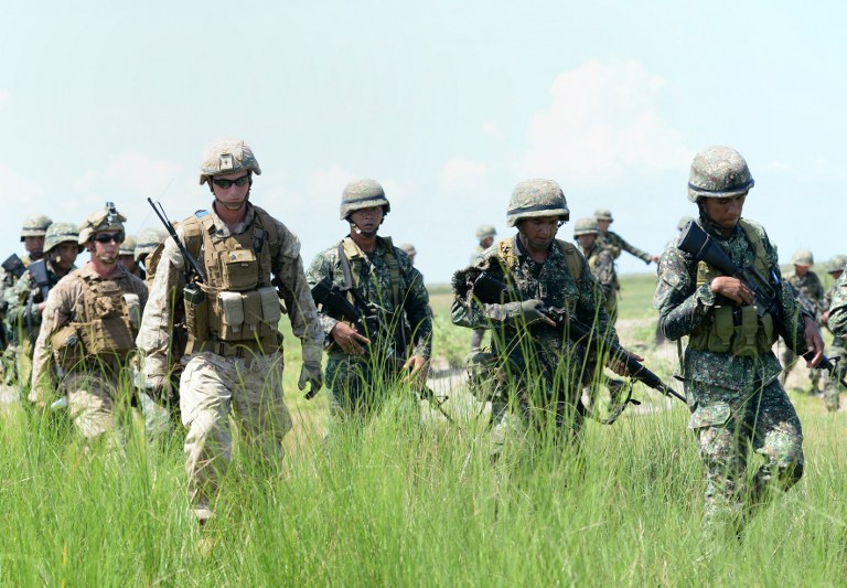 This photo taken on October 9, 2015 shows Philippine marines (in green) and their US counterparts (in light brown) are pictured after simulating an assault during the annual Philippines-US amphibious landing exercise (PHIBLEX) at the navy base facing the South China Sea in San Antonio, Zambales province, north of Manila. The Philippines and the United States launch war games later on October 4, 2016 against the unusual threat of US forces being ejected from the Southeast Asian nation as its firebrand leader pivots to China. / AFP PHOTO / TED ALJIBE