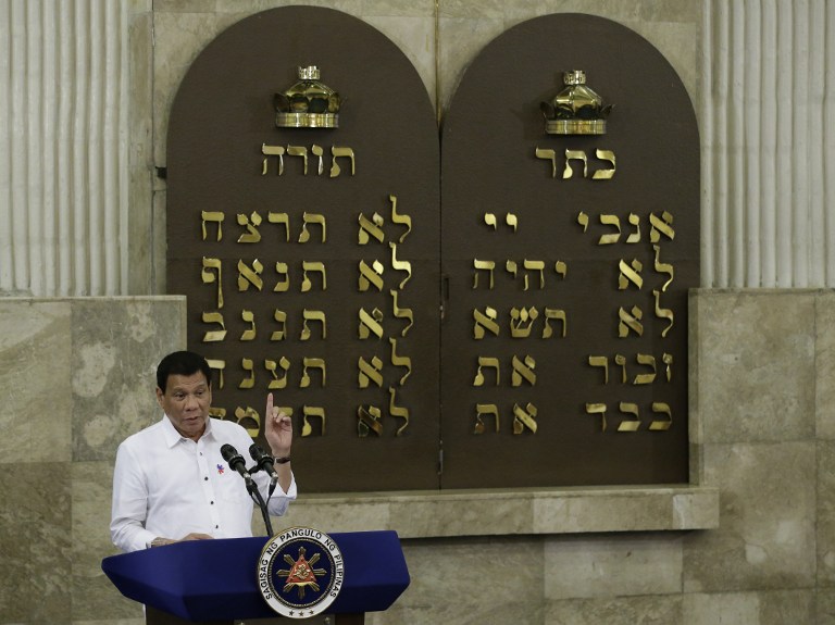 Philippine President Rodrigo Duterte gestures during his speech at the Beit Yaacov Synagogue, The Jewish Association of the Philippines in Makati, south of Manila on October 4, 2016. Philippine President Rodrigo Duterte on October 2 apologised to Jews for comparing himself with Adolf Hitler but said he did nothing wrong and reiterated his desire to kill millions of drug addicts. / AFP PHOTO / POOL / Aaron Favila