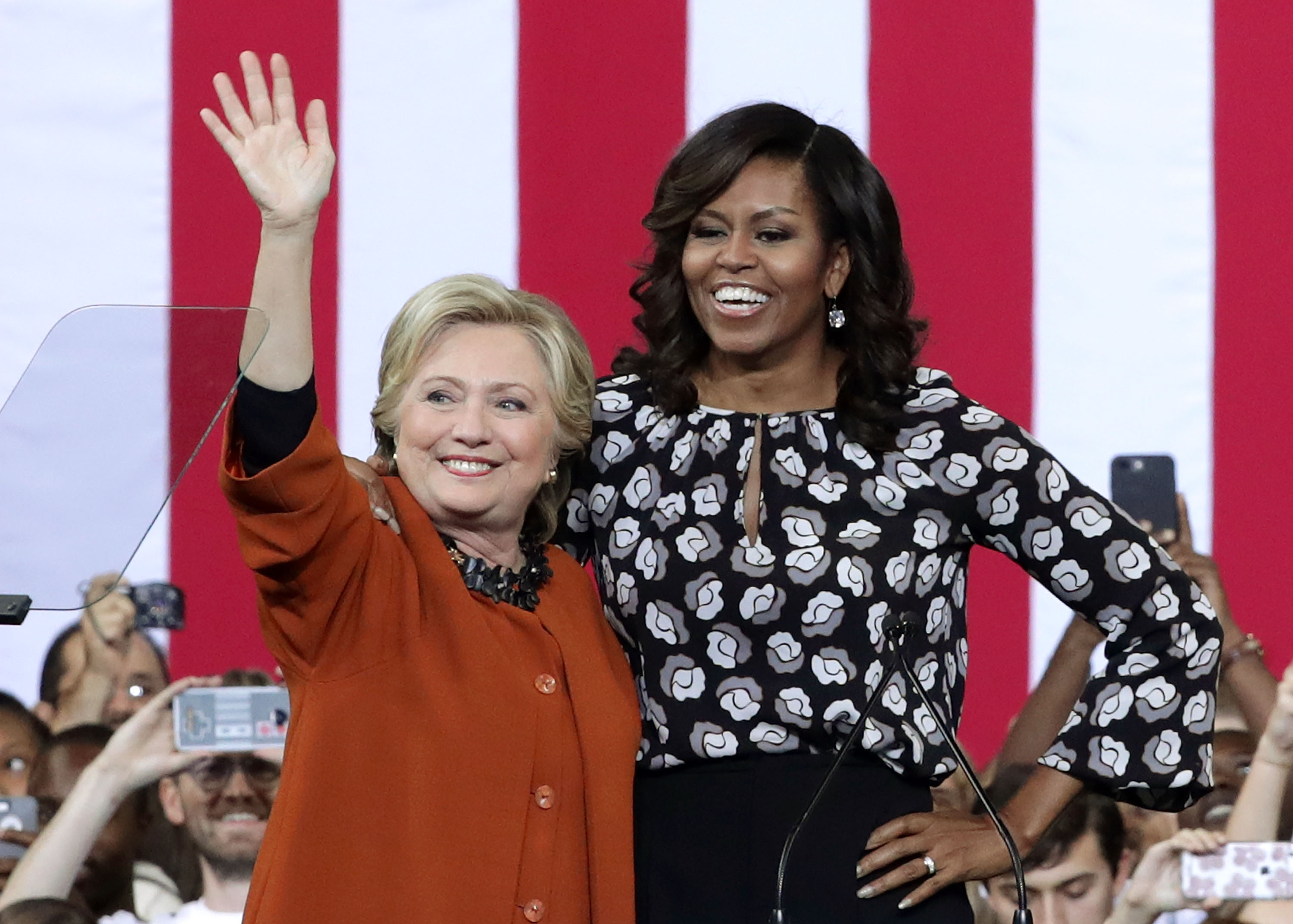 WINSTON-SALEM, NC - OCTOBER 27: Democratic presidential candidate Hillary Clinton (L) and U.S. first lady Michelle Obama (R) greet supporters during a campaign event at the Lawrence Joel Veterans Memorial Coliseum October 27, 2016 in Winston-Salem, North Carolina. The first lady joined Clinton for the first time to campaign for the presidential election. Alex Wong/Getty Images/AFP