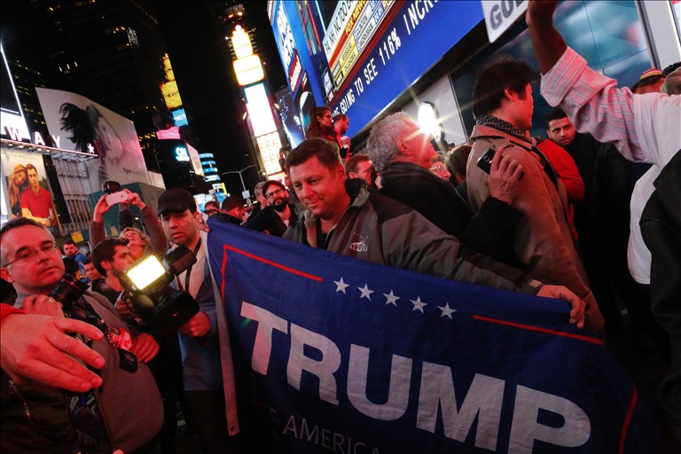 Supporters of US Republican presidential candidate Donald Trump shout slogans as they gather around Times Square to view televised results of the US presidential election on November 8, 2016 in New York. Millions of Americans voted November 8th for their new leader in a historic election that will either elevate Democrat Hillary Clinton as their first woman president or hand power to maverick populist Donald Trump/ EDUARDO MUNOZ ALVAREZ / AFP