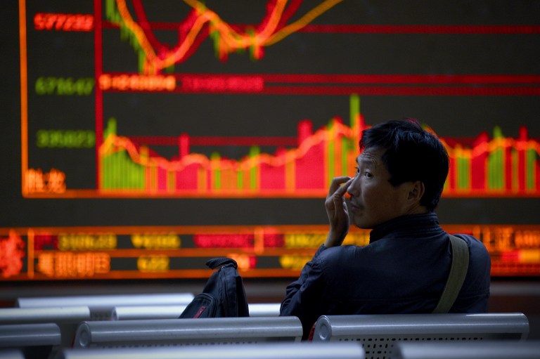 An investor rests in a chair in front of screens showing stock market movements at a securities company in Beijing on November 9, 2016. Stock markets around the region plunged in morning trading on November 9 as incoming results from the US presidential election suggested Donald Trump was leading markets favourite Hillary Clinton in the White House race. / AFP PHOTO / WANG ZHAO