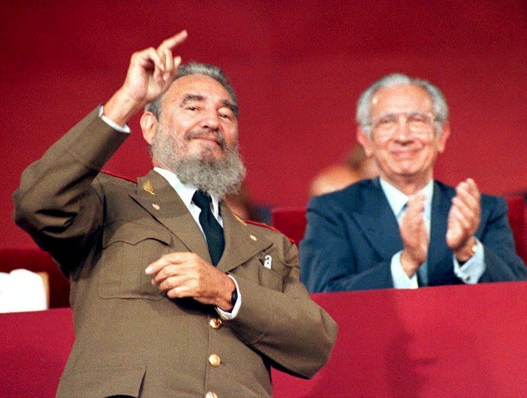 (FILES) This file photo taken on July 24, 1992 shows Cuban President Fidel Castro (L) waving to the Cuban Olympic delegation as they pass the reviewing stand during the opening ceremony of the Summer Olympics. Cuban revolutionary icon Fidel Castro died late on November 25, 2016 in Havana, his brother, President Raul Castro, announced on national television. / AFP PHOTO / IOPP / Alberto MARTIN