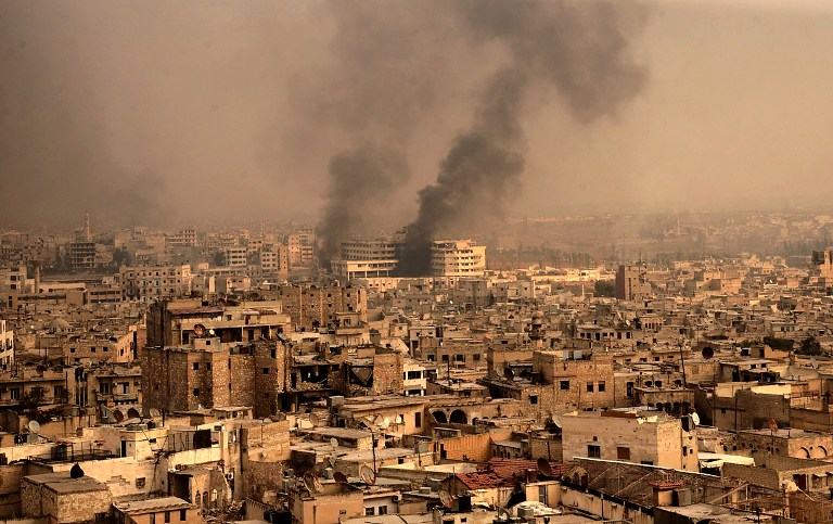 A general view taken from Aleppo's citadel show fumes rising following shelling on neighbourhoods in the old city on December 7, 2016. / AFP PHOTO / GEORGE OURFALIAN