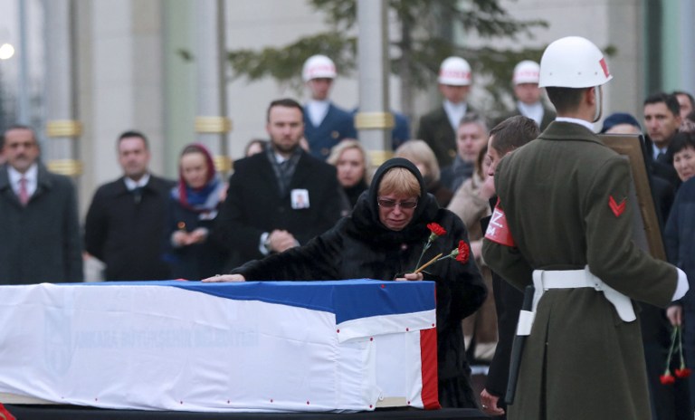 Marina Davydova Karlova, widow of late Russian Ambassador to Turkey Andrei Karlov, reacts in front of his coffin, during a ceremonial farewell with full state honours on the tarmac of Ankara's Esenboga Airport on December 20, 2016, before the coffin is transported on a Russian plane for Moscow.  Veteran diplomat Andrei Karlov was shot nine times in the back by an off-duty Turkish policeman at the opening of an exhibition of Russian photography on December 19, 2016. The brazen killing stunned Ankara and Moscow, which have rowed repeatedly over the Syria conflict but in recent weeks have begun cooperating closely on the evacuations from war-wrecked Aleppo.  / AFP PHOTO / ADEM ALTAN