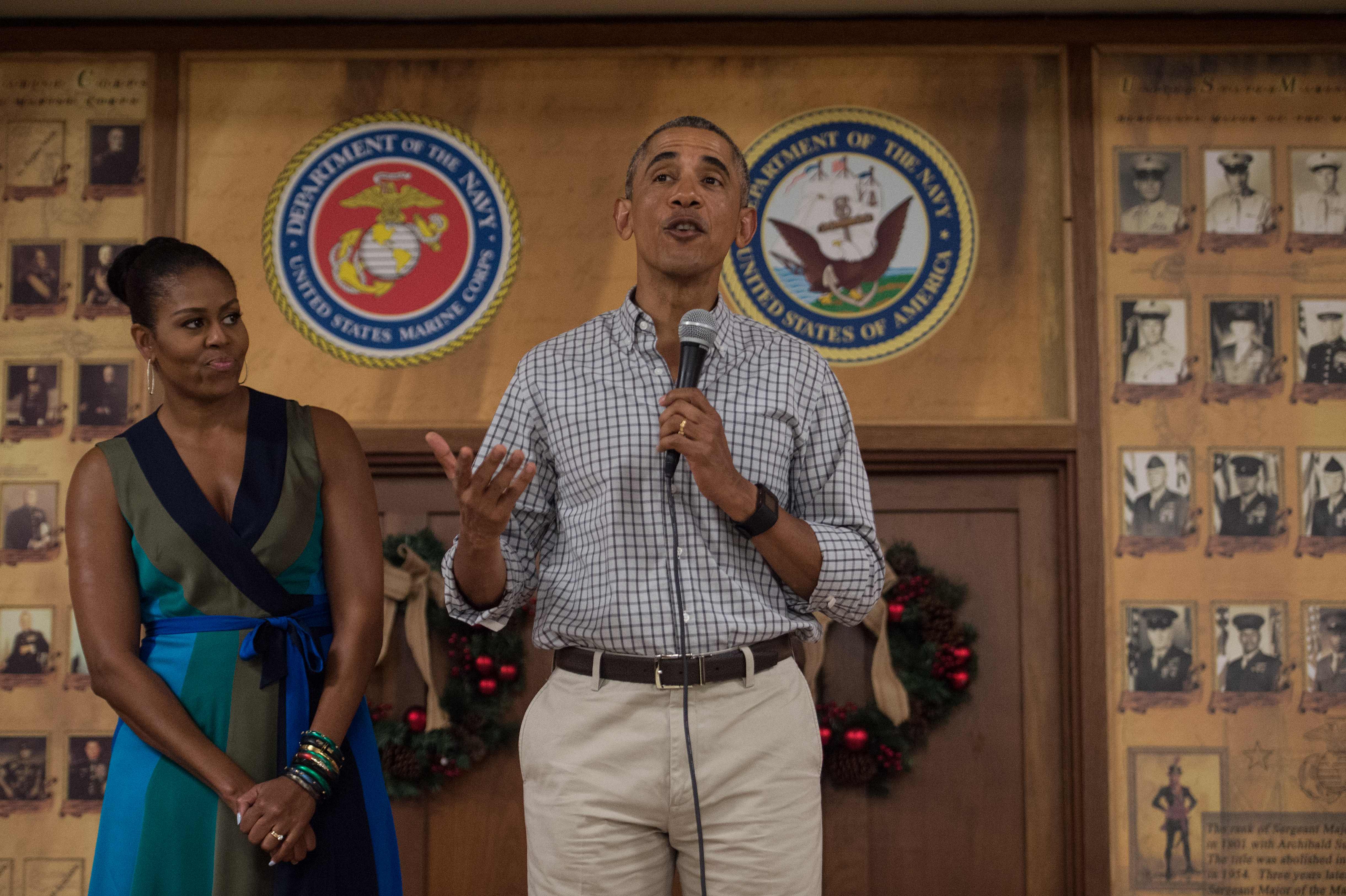 US President Barack Obama addresses troops with First Lady Michelle Obama at Marine Corps Base Hawaii in Kailua on December 25, 2016. / AFP PHOTO / NICHOLAS KAMM