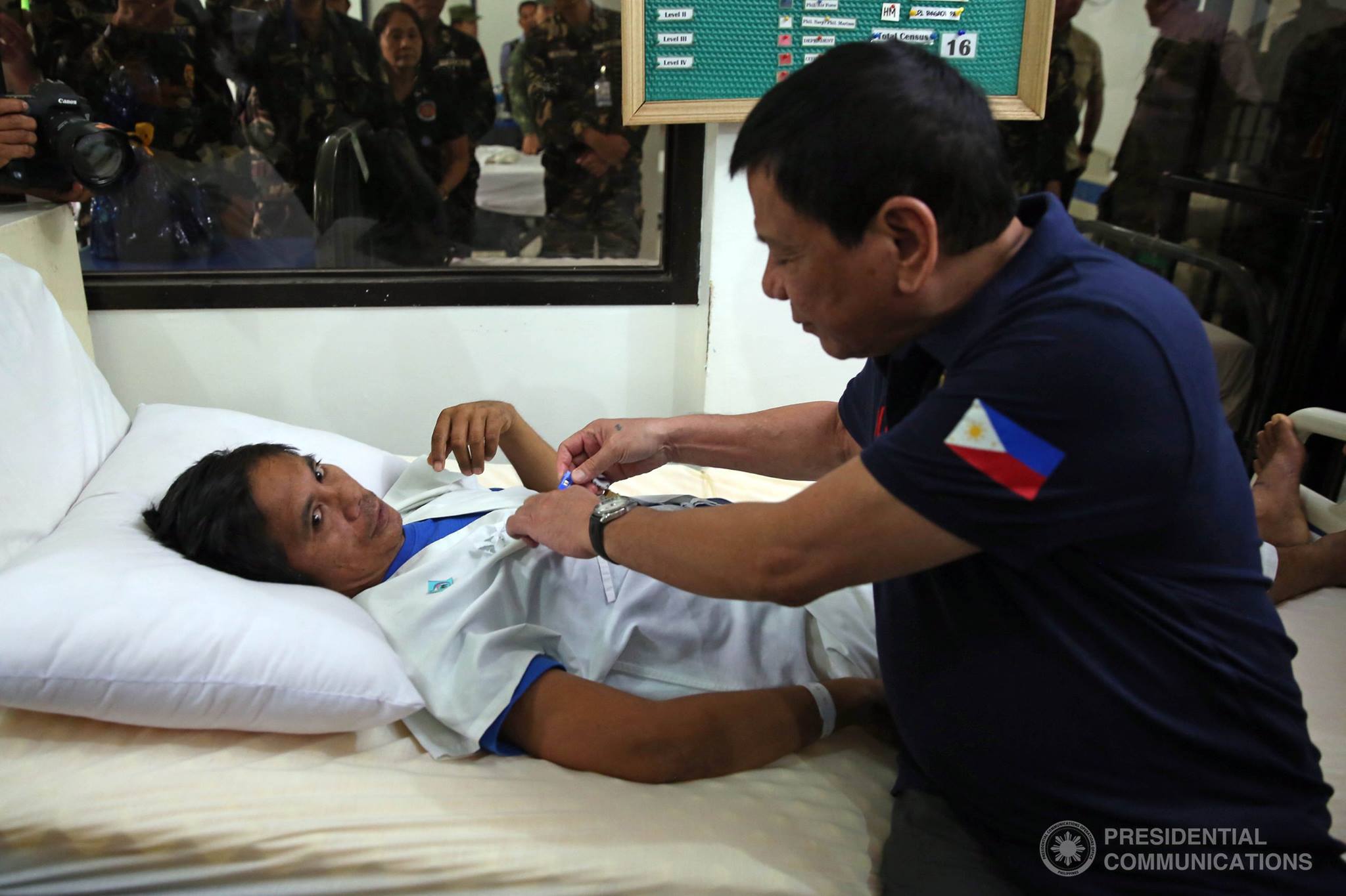 President Rodrigo Duterte pins a medal to one of the soldiers wounded in recent military encounters with the Abu Sayyaf Group (ASG) in Basilan during his visit to Camp Navarro General Hospital in Zamboanga City on December 17, 2016.  (Photo from Presidential Communications, Malacanang) 