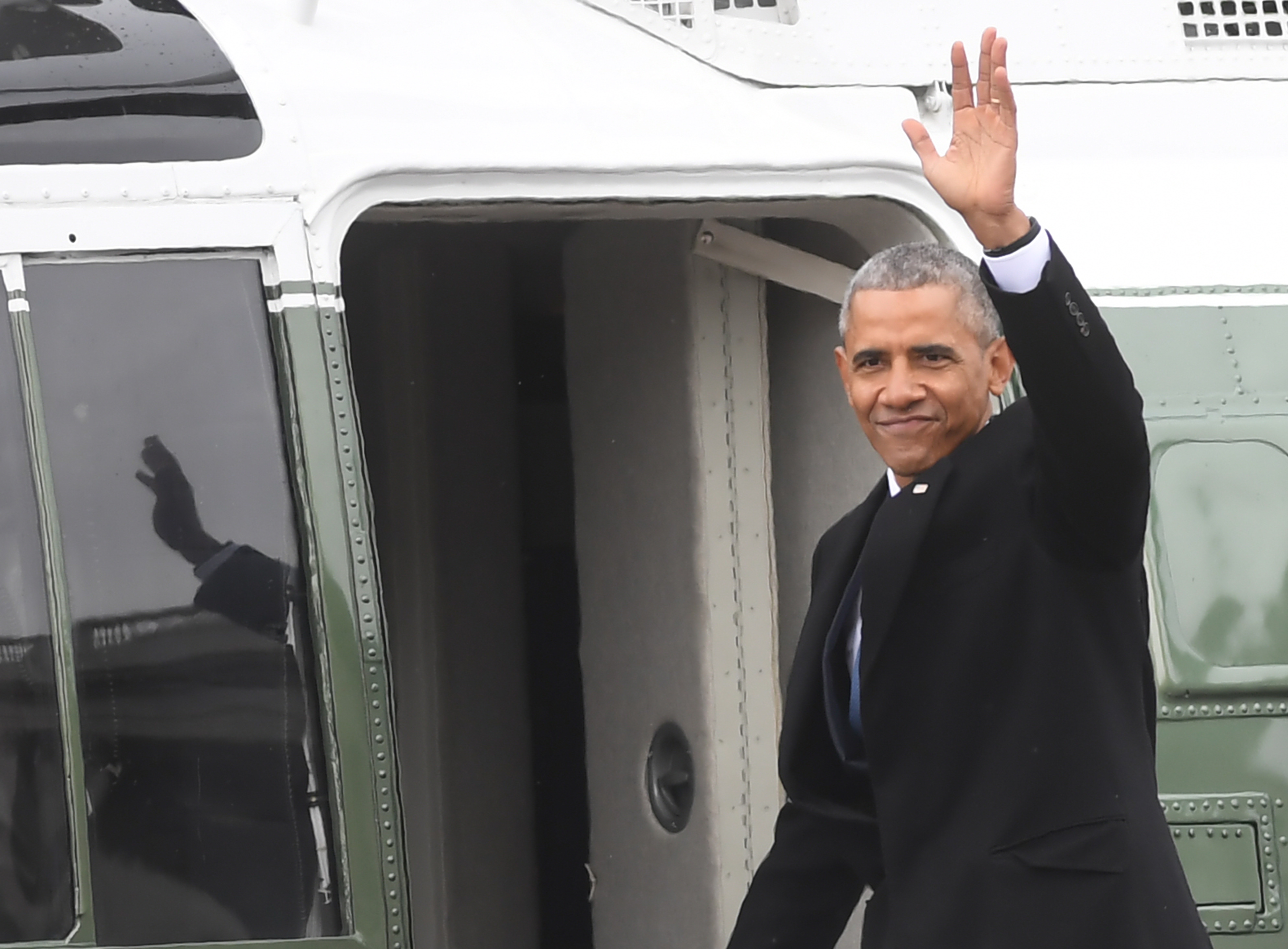 Former President Barack Obama waves as he departs the US Capitol after inauguration ceremonies in Washington, DC, on January 20, 2017. / AFP PHOTO / JIM WATSON