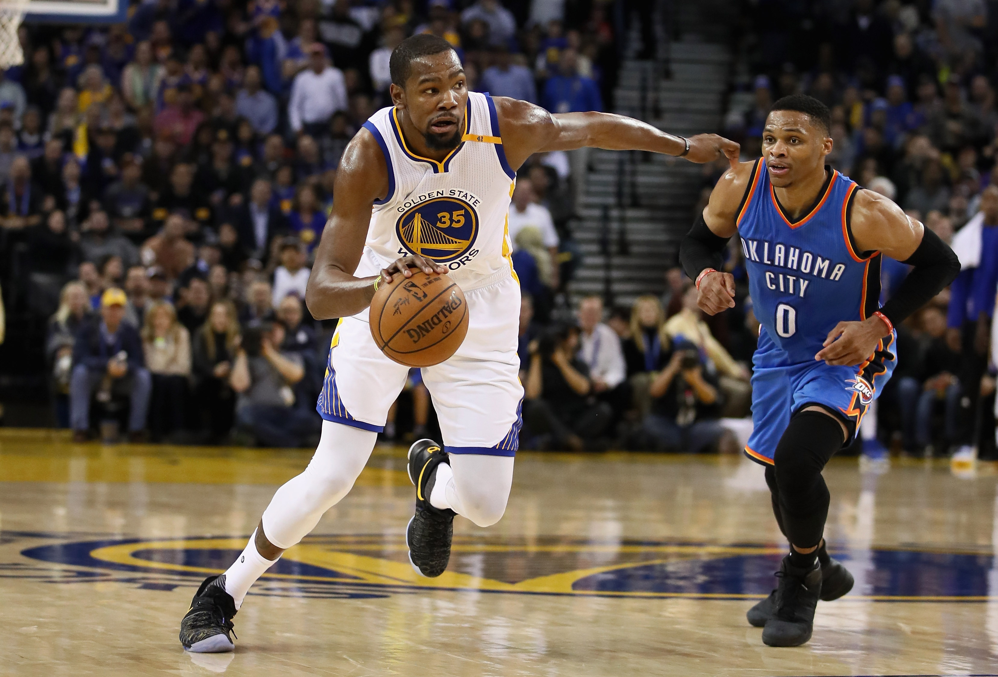 OAKLAND, CA - JANUARY 18: Kevin Durant #35 of the Golden State Warriors dribbles past Russell Westbrook #0 of the Oklahoma City Thunder at ORACLE Arena on January 18, 2017 in Oakland, California. NOTE TO USER: User expressly acknowledges and agrees that, by downloading and or using this photograph, User is consenting to the terms and conditions of the Getty Images License Agreement.   Ezra Shaw/Getty Images/AFP