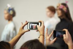 Visitors use mobile phones to photograph models as they present creations from designer Bora Aksu, during the 2017 Spring / Summer catwalk show during London Fashion Week in London on September 16, 2016. / AFP PHOTO / NIKLAS HALLE'N