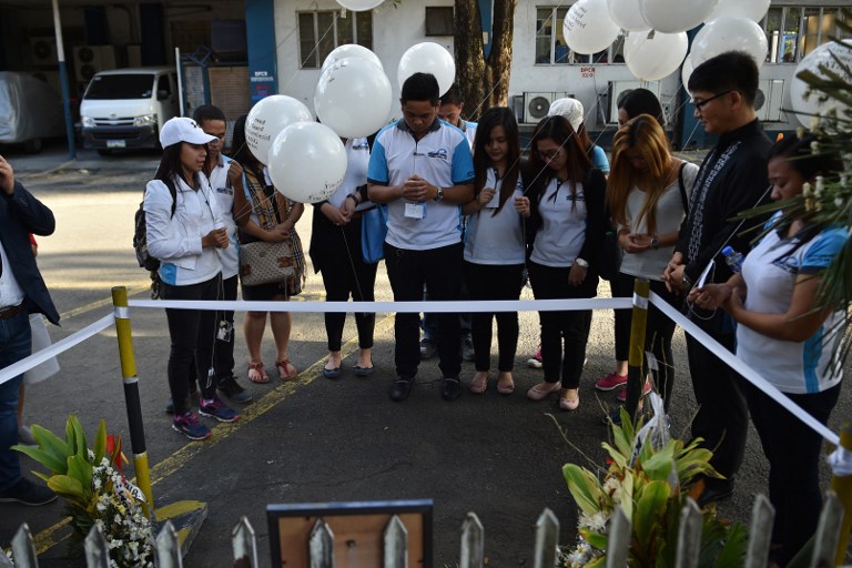 Filipino staff of late South Korean businessman Jee Ick-Joo, who was allegedly killed by suspected policemen, offer prayers at the crime scene inside the police headquarters in Manila on February 6, 2017.  The South Korean businessman was allegedly kidnapped by Philippine policemen under the guise of a raid on illegal drugs and murdered at the national police headquarters in Manila, authorities said on January 18. / AFP PHOTO / TED ALJIBE