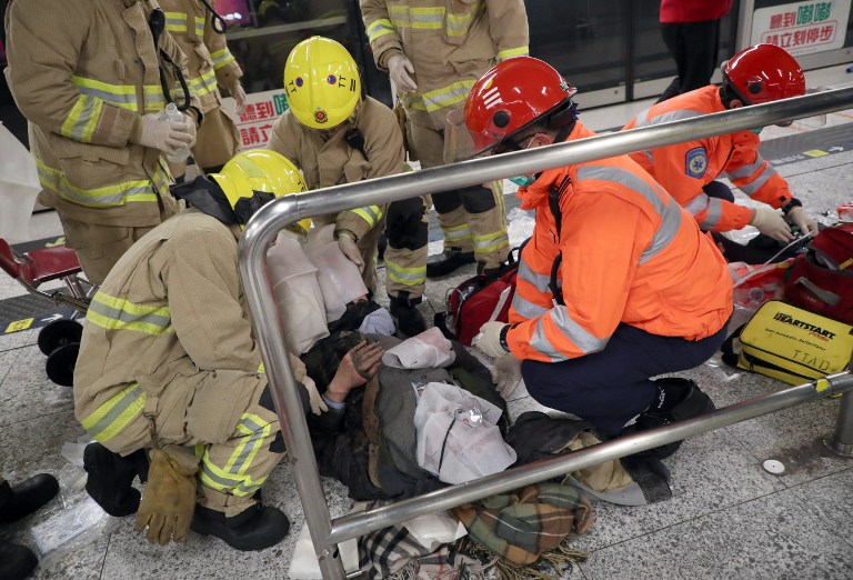 This handout picture released by Hong Kong-based newspaper Apple Daily shows a passenger receiving medical assistance by Hong Kong rescue personnel after a fire broke out inside an MTR metro train carriage from the scene in Hong Kong on February 10, 2017. Hong Kong police said February 10 they have arrested a man for arson after a fire engulfed a subway train, injuring 17 people and triggering the evacuation of a major station during rush hour. Videos showed chaos on the platform at Tsim Sha Tsui station, with the cabin on fire and one man lying on the platform with his clothes ablaze as bystanders tried to help him.' / AFP PHOTO / Apple Daily / Handout / - Hong Kong OUT - Taiwan OUT / RESTRICTED TO EDITORIAL USE - MANDATORY CREDIT "AFP PHOTO / Apple Daily" - NO MARKETING NO ADVERTISING CAMPAIGNS - DISTRIBUTED AS A SERVICE TO CLIENTS