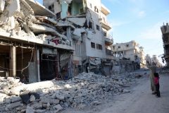 A man takes a picture of destroyed buildings on a street in the northwestern border town of al-Bab on February 23, 2017 after Turkish-backed Syrian rebels fully captured the town from the Islamic State (IS) group. Al-Bab, just 25 kilometres (15 miles) south of the Turkish border, was the last IS stronghold in the northern Syrian province of Aleppo.  / AFP PHOTO / Nazeer al-Khatib