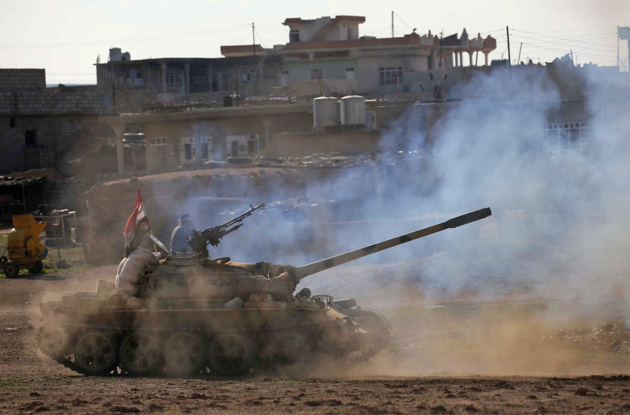 Iraqi government forces supported by fighters from the Abbas Brigade, which fight under the umbrella of the Shiite popular mobilisation units, advance in village of Badush some 15 kilometres northwest of Mosul during the ongoing battle to retake the city's west from Islamic State (IS) group jihadists on March 7, 2017.   / AFP PHOTO / Mohammed SAWAF