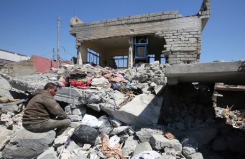 An Iraqi man sits amid the rubble of destroyed houses in the Mosul al-Jadida area on March 26, 2017, following air strikes in which civilians have been reportedly killed during an ongoing offensive against the Islamic State (IS) group.   Iraq is investigating air strikes in west Mosul that reportedly killed large numbers of civilians in recent days, a military spokesman said.  / AFP PHOTO / AHMAD AL-RUBAYE