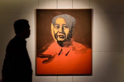 A man walks past Mao by US artist Andy Warhol, 1973, an acrylic and silkscreen ink on canvas, during a pre-auction preview by Sotheby's in Hong Kong on March 17, 2017. An Andy Warhol portrait of former Chinese leader Mao Zedong will be auctioned in Hong Kong in a landmark sale that could fetch 15 million USD -- but mainland buyers may be wary of putting in a bid. The classic 1973 screen print by the legendary US pop artist will go under the hammer at Sotheby's next month with the highest estimate the auction house has ever seen for a painting in Asia. It comes as demand grows in the region for a wider variety of works, driven by appetite in China. The auction house describes the event as the first "significant" sale of Western contemporary art in Hong Kong. / AFP PHOTO / Anthony WALLACE / RESTRICTED TO EDITORIAL USE - MANDATORY MENTION OF THE ARTIST UPON PUBLICATION - TO ILLUSTRATE THE EVENT AS SPECIFIED IN THE CAPTION