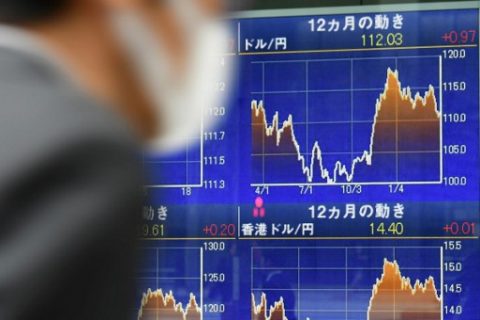 A passerby walks in front of a forex indicator at the window of a security company in Tokyo on March 31, 2017. Tokyo stocks opened higher on March 31 as exporters and banks rose on a weaker yen and solid US growth data. / AFP PHOTO / Toshifumi KITAMURA