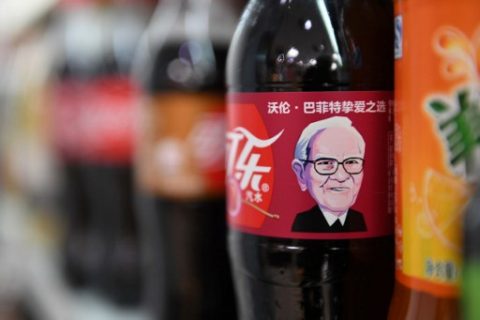 A Cherry Coke bottle featuring an image of US investor Warren Buffet is seen on a shelf at a convenience store in Beijing on April 5, 2017. The likeness of billionaire Warren Buffett has graced Cherry Coke cans in China, where the company's largest investor enjoys a legendary reputation. Coca-Cola announced over the weekend that a grinning cartoon portrait of the American business magnate would adorn cans and bottles of his favourite flavour after it was introduced in the country on March 10. / AFP PHOTO / GREG BAKER