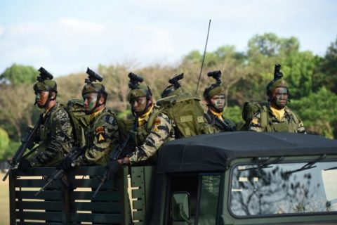 In this photo taken on April 4, 2017 Philippine army soldiers stand aboard a vehicle during a march and review as part of their anniversary celebration at Fort Bonifacio in Manila. A Philippine police officer was killed on April 11, 2017 in clashes with 10 suspected members of the Abu Sayyaf kidnap group on the resort island of Bohol, authorities said. / AFP PHOTO / TED ALJIBE