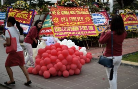 An Indonesian takes a photograph next to farewell wreaths for Basuki Tjahaja Purnama also known as Ahok, Jakarta's first non-Muslim governor for half a century and its first ethnic Chinese leader, at cityhall in Jakarta, on May 10, 2017. Jakarta's Christian governor was jailed for two years after being found guilty of blasphemy, in a shock decision that has stoked concerns over rising religious intolerance in the world's most populous Muslim-majority nation. / AFP PHOTO / BAY ISMOYO 