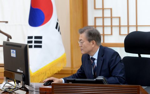 South Korea's new President Moon Jae-In puts electronically his signature to an order to scrap state-issued school history textbooks in his office at the presidential Blue House in Seoul on May 12, 2017. Moon Jae-In on May 12 scrapped state-issued school history textbooks introduced by his ousted predecessor, saying they represented an "outdated and one-sided" view of the past, his office said. / AFP PHOTO / YONHAP / str / REPUBLIC OF KOREA OUT NO ARCHIVES RESTRICTED TO SUBSCRIPTION USE