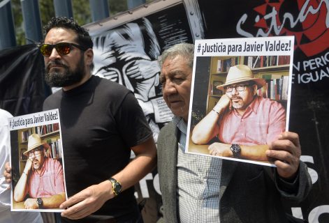 Journalists show pictures of Mexican journalist Javier Valdez, murdered on the eve, during a protest by journalists in Mexico City on May 16, 2017. Mexico ranks third in the world for the number of journalists killed, after Syria and Afghanistan, according to media rights group Reporters Without Borders (RSF). / AFP PHOTO / PEDRO PARDO