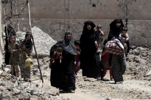 Displaced Iraqi women walk towards Iraq forces as they flee their homes in Mosul's western Al-Shifa district on June 15, 2017, during the ongoing offensive by Iraqi forces to retake the city from Islamic State (IS) group fighters. / AFP PHOTO / MOHAMED EL-SHAHED