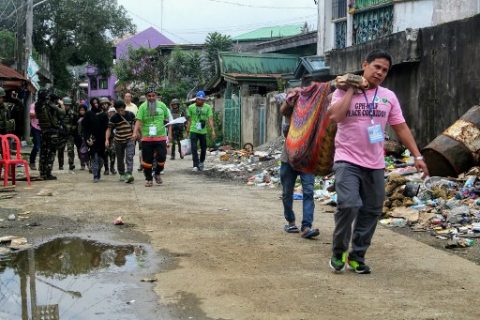 This handout photo taken on June 25, 2017 and released on June 26 by the 1st Infantry Battalion of the Philippine Army shows rescuers escorting trapped residents (centre L) and carrying the body (R) of a dead resident from ground zero of the fighting between government forces and Islamist militants in Marawi, on the southern island of Mindanao, after a ceasefire was declared. An eight-hour ceasefire in the Philippine city allowing residents to celebrate the end of Ramadan came to an abrupt end during the afternoon on June 25 as the government continued its offensive against Islamist militants occupying parts of war-torn Marawi. / AFP PHOTO / 1ST NFANTRY BATTALION PHILIPPINE ARMY / Handout / -----EDITORS NOTE --- RESTRICTED TO EDITORIAL USE - MANDATORY CREDIT "AFP PHOTO / 1ST NFANTRY BATTALION PHILIPPINE ARMY" - NO MARKETING - NO ADVERTISING CAMPAIGNS - DISTRIBUTED AS A SERVICE TO CLIENTS