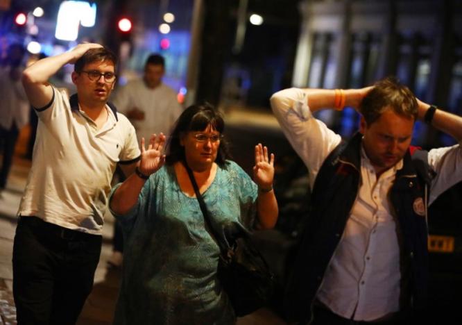 People leave the area with their hands up after an incident near London Bridge in London, Britain June 4, 2017. REUTERS/Neil Hall